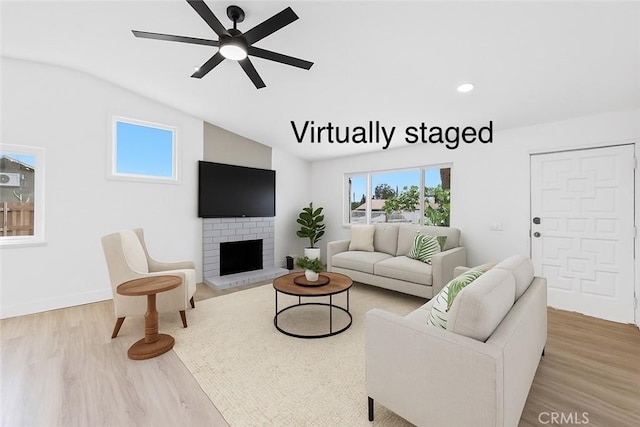 22959 Vought St, Moreno Valley, CA 92553 - living room featuring vaulted ceiling, light wood-type flooring, a ceiling fan, a fireplace, and recessed lighting