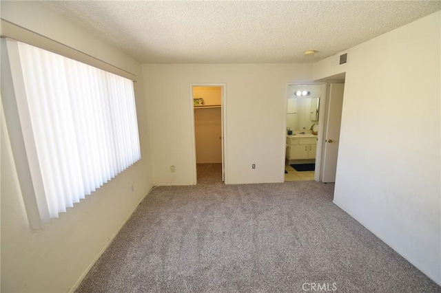 10246 Chaparral Way Unit G, Rancho Cucamonga, CA 91730 - unfurnished bedroom with carpet floors, a spacious closet, a textured ceiling, and ensuite bathroom