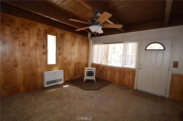 2062 9th Ln, Big Bear City, CA 92314 - carpeted foyer entrance featuring heating unit, a wood stove, wooden walls, a wood ceiling with exposed beams, and ceiling fan
