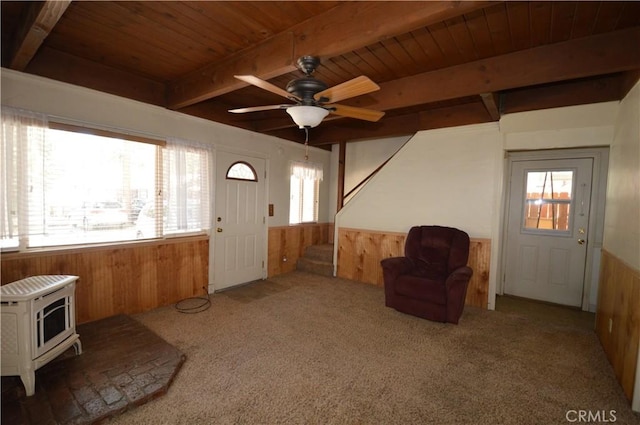 2062 9th Ln, Big Bear City, CA 92314 - living area featuring wooden walls, wainscoting, a wood ceiling with exposed beams, stairs, and carpet