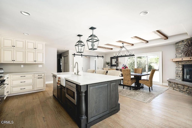 3041 Fairlea Rd, Santa Ynez, CA 93460 - kitchen with stainless steel appliances, light countertops, a barn door, wood finished floors, and cream cabinets