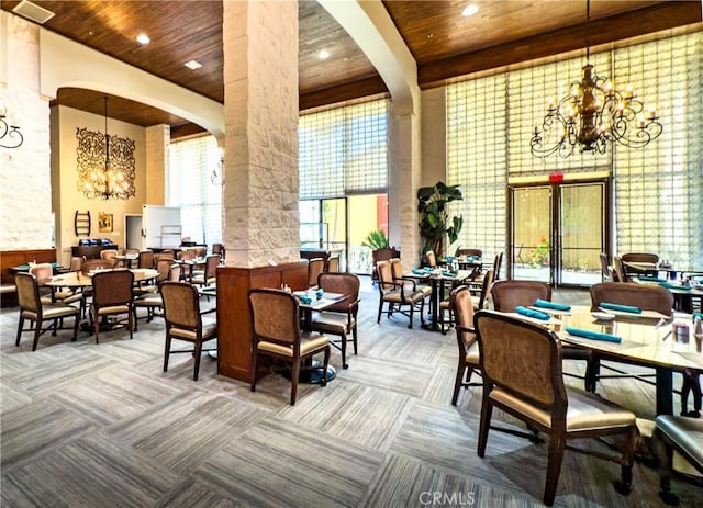 24055 W Paseo Del Lago Unit 753, Laguna Woods, CA 92637 - dining space with a chandelier, ornate columns, wooden ceiling, carpet floors, and a towering ceiling