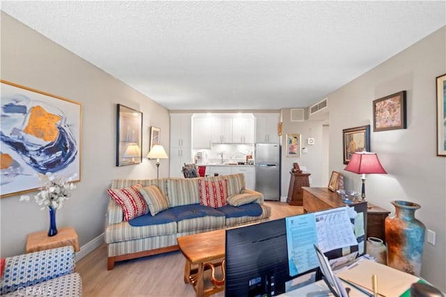 24055 W Paseo Del Lago Unit 753, Laguna Woods, CA 92637 - living room with light wood finished floors and a textured ceiling