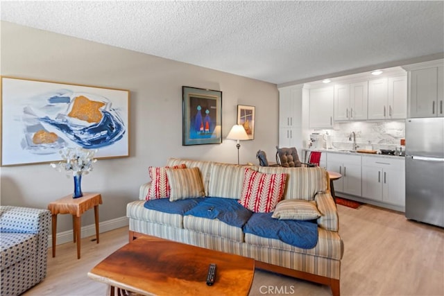 24055 W Paseo Del Lago Unit 753, Laguna Woods, CA 92637 - living room with light wood finished floors and a textured ceiling