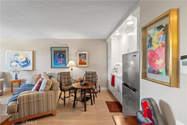 24055 W Paseo Del Lago Unit 753, Laguna Woods, CA 92637 - living room featuring a textured ceiling and light wood-style flooring