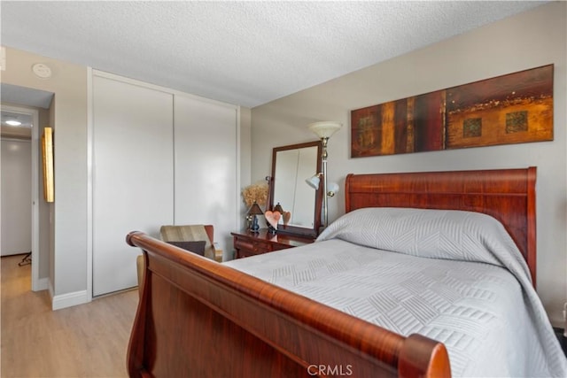 24055 W Paseo Del Lago Unit 753, Laguna Woods, CA 92637 - bedroom with light wood-type flooring, a closet, and a textured ceiling