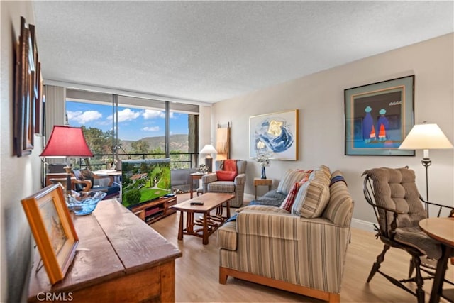 24055 W Paseo Del Lago Unit 753, Laguna Woods, CA 92637 - living area featuring a textured ceiling, floor to ceiling windows, and light wood-type flooring