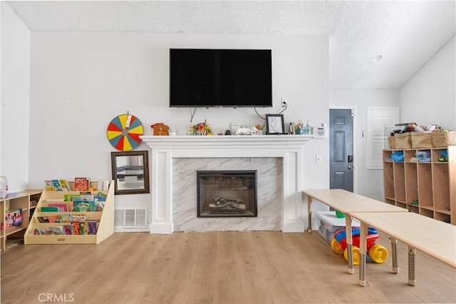 25211 Dana Ln, Moreno Valley, CA 92551 - playroom featuring wood finished floors, a high end fireplace, and a textured ceiling