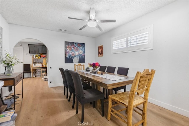 25211 Dana Ln, Moreno Valley, CA 92551 - dining space with light wood finished floors, a ceiling fan, arched walkways, and a textured ceiling