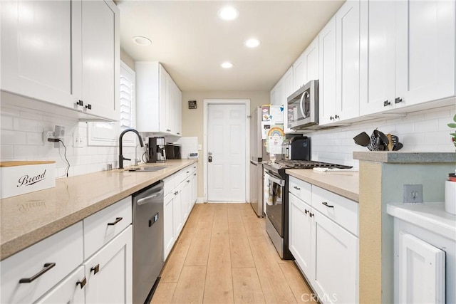 25211 Dana Ln, Moreno Valley, CA 92551 - kitchen featuring stainless steel appliances, recessed lighting, backsplash, white cabinetry, and light wood finished floors