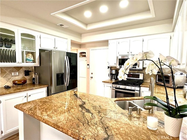 27721 Rubidoux, Mission Viejo, CA 92692 - kitchen featuring stainless steel appliances, light stone countertops, backsplash, white cabinetry, and a raised ceiling