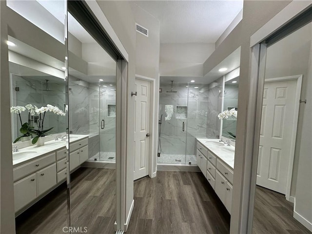 27721 Rubidoux, Mission Viejo, CA 92692 - bathroom with two vanities, a marble finish shower, wood finished floors, and recessed lighting