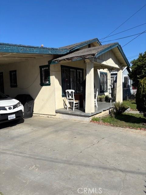 711 N Crane Ave, Compton, CA 90221 - view of front facade featuring a porch, stucco siding, and a carport