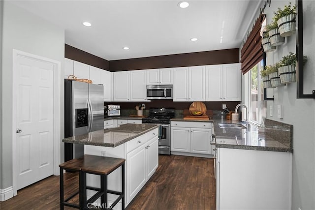 775 Via Blairo, Corona, CA 92879 - kitchen with stainless steel appliances, dark wood-style floors, a kitchen island, white cabinetry, and dark stone countertops