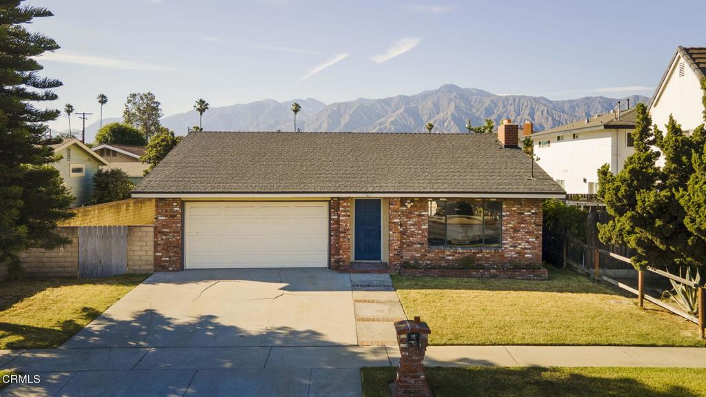 9465 E Camino Real Ave, Arcadia, CA 91007 - view of front of home featuring brick siding, a garage, a mountain view, driveway, and a shingled roof