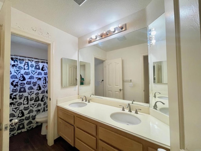 659 Rosita Ct, Chula Vista, CA 91910 - bathroom with double vanity, wood finished floors, and a textured ceiling