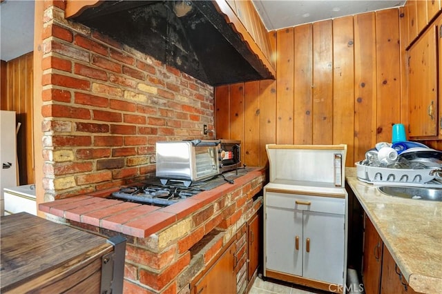 12108 Muriel Dr, Lynwood, CA 90262 - kitchen featuring extractor fan, wood walls, and brown cabinetry