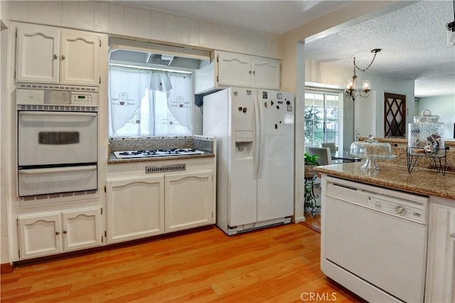 12108 Muriel Dr, Lynwood, CA 90262 - kitchen with white appliances, a warming drawer, premium range hood, light wood-type flooring, and a chandelier