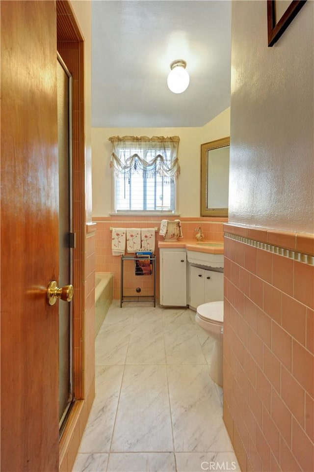 12108 Muriel Dr, Lynwood, CA 90262 - full bathroom with tile walls, a garden tub, a wainscoted wall, marble look tile flooring, and vanity