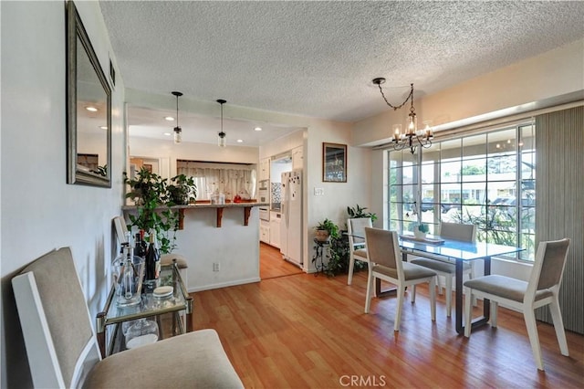 12108 Muriel Dr, Lynwood, CA 90262 - dining space with a textured ceiling, a chandelier, light wood-style flooring, and recessed lighting