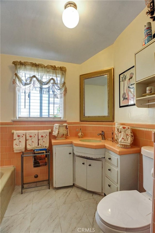 12108 Muriel Dr, Lynwood, CA 90262 - full bath featuring tile walls, a bath, a wainscoted wall, vanity, and marble finish flooring