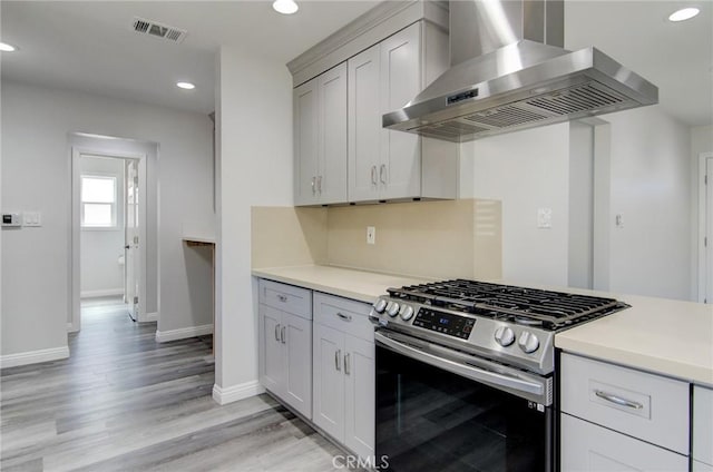 12517 Walcroft St, Lakewood, CA 90715 - kitchen featuring wall chimney exhaust hood, stainless steel range with gas stovetop, light countertops, recessed lighting, and light wood finished floors