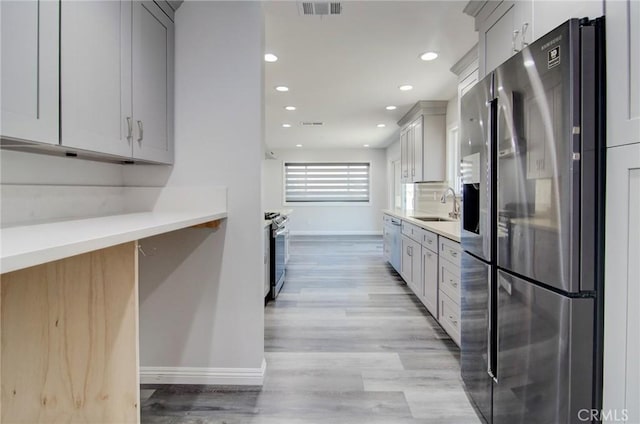 12517 Walcroft St, Lakewood, CA 90715 - kitchen with stainless steel appliances, light wood-type flooring, recessed lighting, light countertops, and gray cabinetry