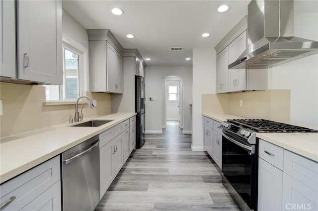 12517 Walcroft St, Lakewood, CA 90715 - kitchen featuring wall chimney exhaust hood, appliances with stainless steel finishes, recessed lighting, light countertops, and light wood-style floors