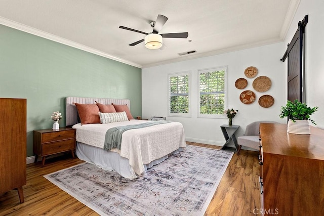 5 Duxbury St, Ladera Ranch, CA 92694 - bedroom featuring ornamental molding, wood finished floors, ceiling fan, and a barn door