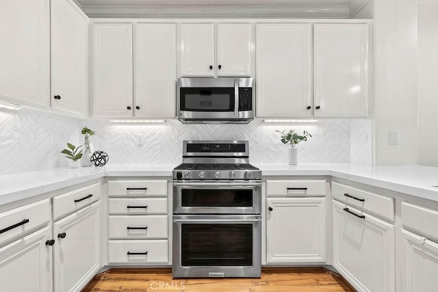 5 Duxbury St, Ladera Ranch, CA 92694 - kitchen featuring appliances with stainless steel finishes, light countertops, white cabinetry, tasteful backsplash, and light wood-style floors