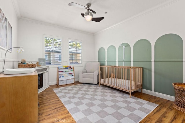 5 Duxbury St, Ladera Ranch, CA 92694 - bedroom with light wood-style floors, a nursery area, ornamental molding, and a ceiling fan