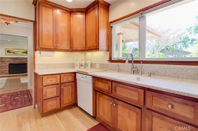 1251 Hackett Ave, Long Beach, CA 90815 - kitchen featuring dishwasher, brown cabinets, light wood-type flooring, light stone counters, and a fireplace