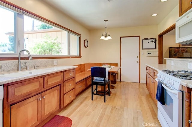 1251 Hackett Ave, Long Beach, CA 90815 - kitchen with white appliances, light wood-style flooring, brown cabinets, hanging light fixtures, and recessed lighting