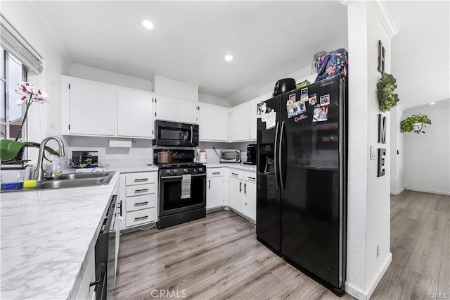 13750 Hubbard St Unit 77, Sylmar, CA 91342 - kitchen with black appliances, light countertops, light wood-type flooring, white cabinetry, and recessed lighting