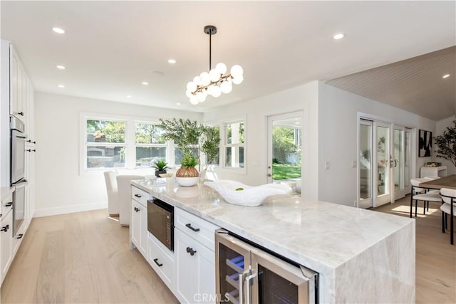 19281 Sierra Inez Rd, Irvine, CA 92603 - kitchen with beverage cooler, stainless steel oven, black microwave, light wood-style flooring, and recessed lighting
