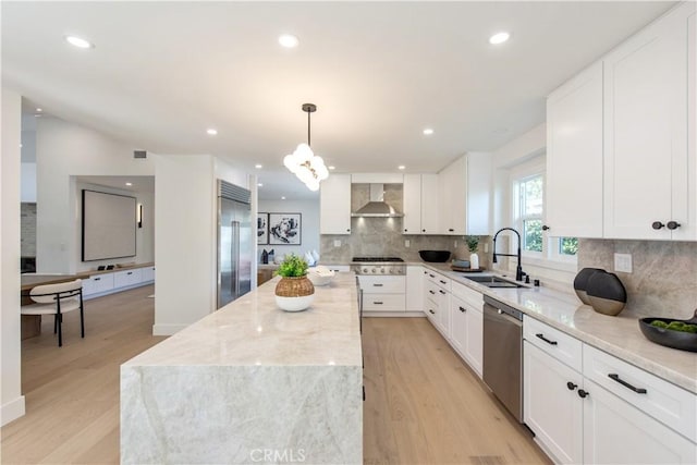 19281 Sierra Inez Rd, Irvine, CA 92603 - kitchen featuring stainless steel appliances, wall chimney range hood, a center island, light wood-type flooring, and light stone countertops