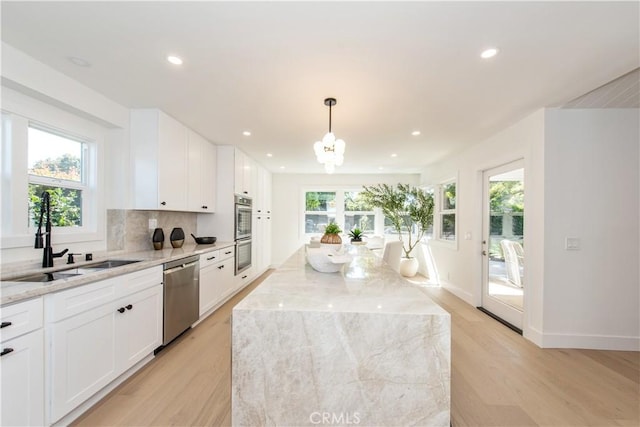 19281 Sierra Inez Rd, Irvine, CA 92603 - kitchen with stainless steel appliances, light wood-style floors, light stone countertops, a chandelier, and recessed lighting