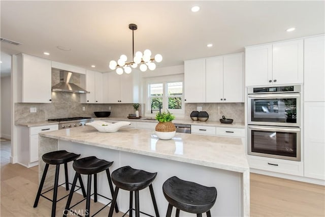 19281 Sierra Inez Rd, Irvine, CA 92603 - kitchen with wall chimney exhaust hood, stainless steel appliances, white cabinets, tasteful backsplash, and recessed lighting
