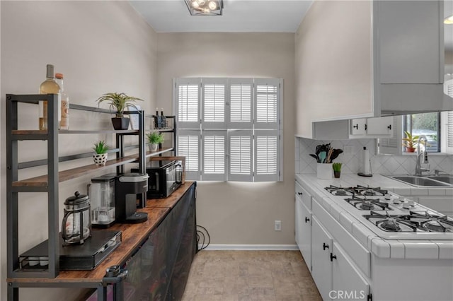 1269 W 1st St, San Pedro, CA 90732 - kitchen featuring healthy amount of natural light, white gas stovetop, tile countertops, and decorative backsplash