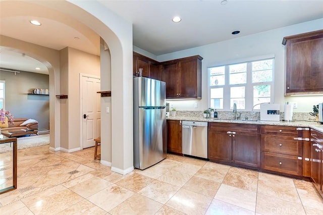440 N Santa Maria St, Anaheim, CA 92801 - kitchen featuring stainless steel appliances, arched walkways, light stone counters, recessed lighting, and dark brown cabinetry