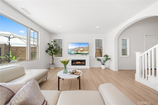 246 Canterbury, Irvine, CA 92618 - living area with a glass covered fireplace, wood finished floors, arched walkways, and recessed lighting