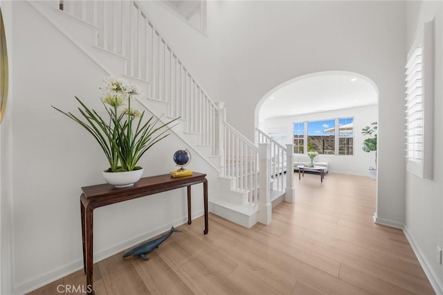 246 Canterbury, Irvine, CA 92618 - hallway featuring stairway, arched walkways, wood finished floors, and a towering ceiling