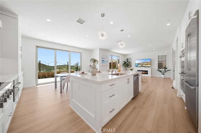 246 Canterbury, Irvine, CA 92618 - kitchen with open floor plan, stainless steel appliances, recessed lighting, white cabinets, and light wood finished floors