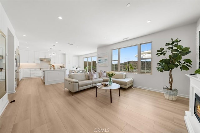 246 Canterbury, Irvine, CA 92618 - living area with a glass covered fireplace, light wood finished floors, and recessed lighting