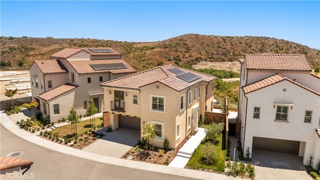 246 Canterbury, Irvine, CA 92618 - view of front facade with a garage, concrete driveway, roof mounted solar panels, and stucco siding