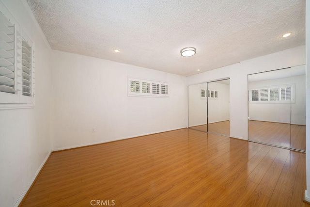 11302 Cheddar St, Norwalk, CA 90650 - unfurnished bedroom with a textured ceiling, wood finished floors, multiple closets, and recessed lighting