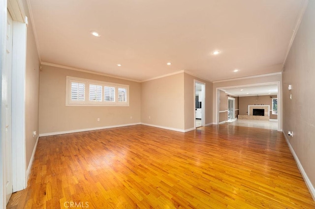 11302 Cheddar St, Norwalk, CA 90650 - unfurnished living room featuring light wood-style flooring, ornamental molding, recessed lighting, and a fireplace with raised hearth