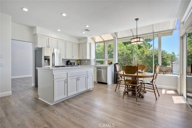 32197 Callesito Fadrique, Temecula, CA 92592 - kitchen featuring stainless steel appliances, backsplash, light wood-style flooring, white cabinetry, and light countertops