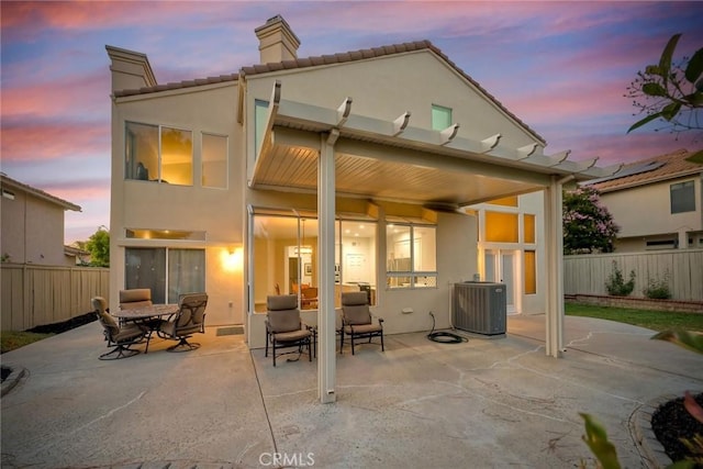 32197 Callesito Fadrique, Temecula, CA 92592 - back of house at dusk featuring a chimney, a patio area, stucco siding, and a tiled roof