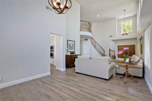 32197 Callesito Fadrique, Temecula, CA 92592 - living area with a chandelier, a towering ceiling, stairway, and light wood-type flooring